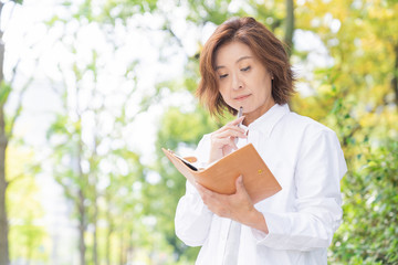 Fototapeta premium シニア女性 外出 スケジュール帳 考える