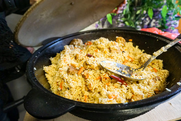 Fragrant friable pilaf, folk traditional dish of Uzbekistan, cauldron full of rice