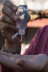 white woman disinfecting her hands with gel alcohol, preventing diseases like covid-19