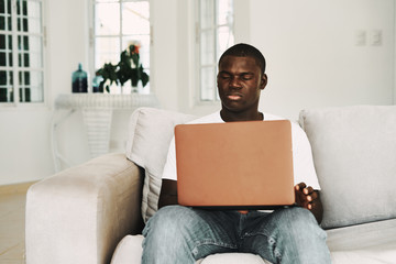 man sitting on sofa with laptop