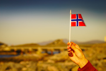 Norwegian flag against Atlantic Road, Norway