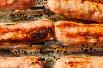 Sausages meat grilling on gas grill