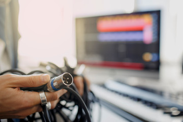 Doesn't know what to do with wires and cords and cables. DJ in broadcasting studio. music producer is composing a song on synthesizer keyboard and computer in recording studio