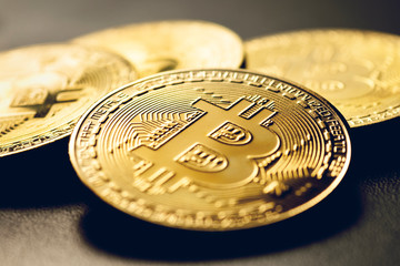 Golden colored bitcoin coins on a black background.