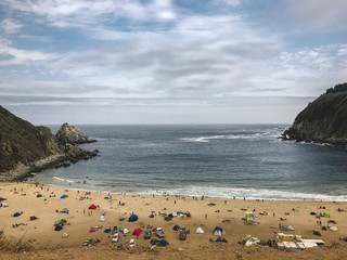 Obraz premium Panoramic view of las Docas Beach by day at summer with campings and tents, Chile