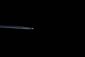 Airplane in a dark sky, it flies in a black sky at the time of the coronavirus