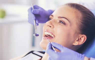 Naklejka premium Young Female patient with open mouth examining dental inspection at dentist office.