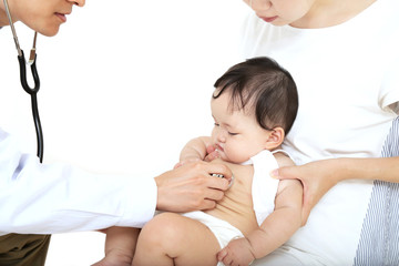 白衣を着た男性医者に聴診器で診察を受ける赤ちゃん。