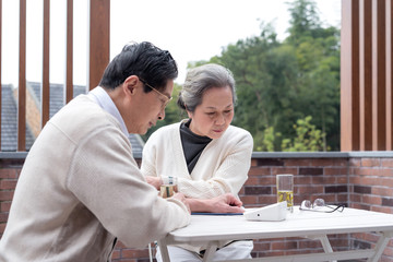Obraz premium An old Asian couple using a sphygmomanometer