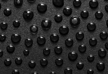 Water drops on black metal surface. 