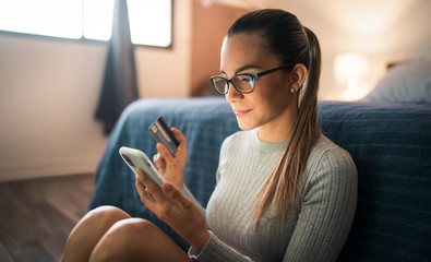 Young White Woman Using Smartphone Shopping Online With Credit Card