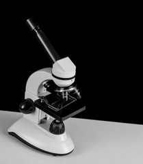 Microscope in black and white side view. Black background with space for text