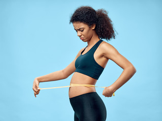 young sporty woman with measure tape