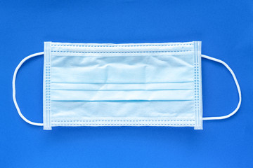 Typical 3 ply surgical face mask with rubber ear straps to cover the mouth and nose