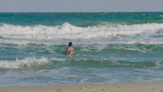 Woman bathing in a stormy sea in Odessa, Ukraine.