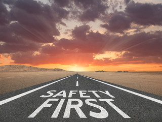 Safety First sign on highway background.