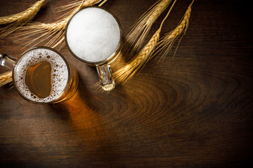 Fototapeta premium Glasses of Light Beer with wheat on the wooden table, copy space for your text