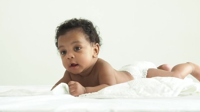 African newborn baby boy lying in bed and wriggle in the morning.Happy , excited , smile and enjoy emotion.He have beautiful eyes.