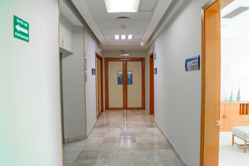 Fototapeta premium A huge brown door in a white corridor in a hospital.