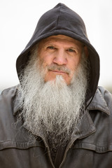 Face of mature bearded hipster man wearing hood