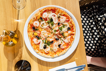 woman eating italian seafood pizza