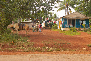 People and horse in front of a small house in Valle de Vi–ales, in central Cuba