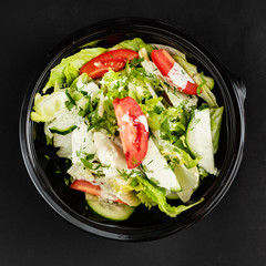 salad with cucumber and tomatoes in plastic box