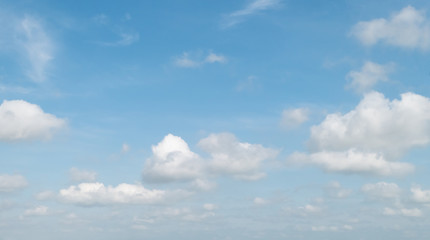Blue sky with white soft clouds. Simple outdoor sky background.