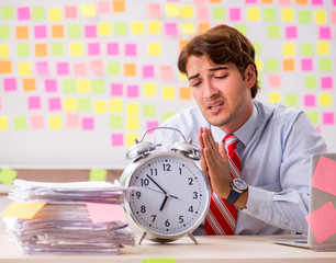 Young handsome man in conflicting priorities concept