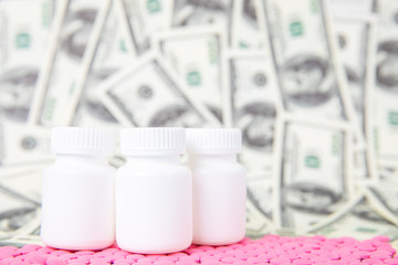 A scattering of pink medical pills and white cans against a background of dollar bills.