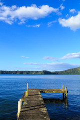 An L-shaped jetty on a calm lake, with wooded hills in the background. Lake Rotoiti, New Zealand