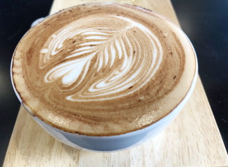 Cappuccino or latte with frothy foam, white coffee cup top view