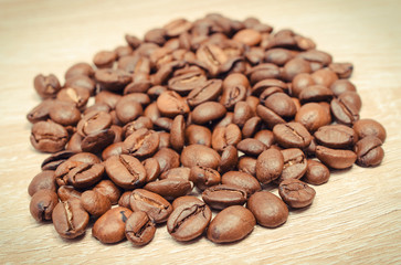 Heap of coffee grains on wooden board