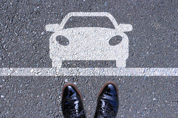 道路の車のアイコンの前に立つ革靴 vehicle icon on the pavement and leather shoes