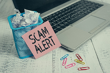 Conceptual hand writing showing Scam Alert. Concept meaning warning someone about scheme or fraud notice any unusual Metallic laptop sticky note bin paper clips vintage table