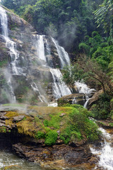 Naklejka na ściany i meble Wet rocks and white spray of water on Vachiratharn waterfall