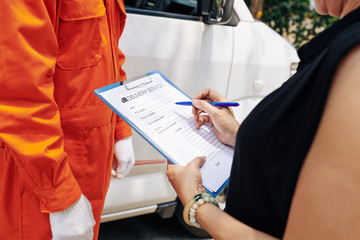 Woman filling delivery service document with personal information and details of order