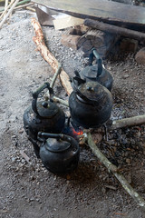 Old kettles with black soot on red bonfire