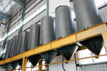 Indoor industrial oil tanks in a refinery warehouse.
