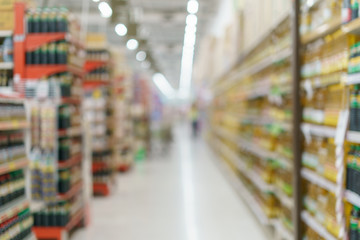 Supermarket blurred background oil bottle and seasoning sauce on shelves at grocery.