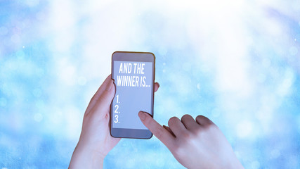 Conceptual hand writing showing And The Winner Is. Concept meaning announcing a demonstrating or...