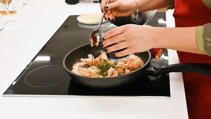 the cook is cooking langoustines. cook in the kitchen. wild shrimp.