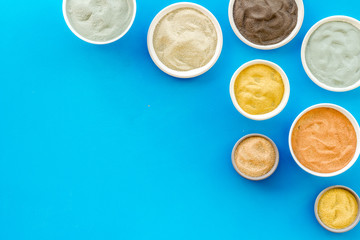 cosmetic clay - Yellow, red, white, blue and black dry powder - top-down flat lay on yellow table copy space