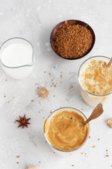 Tasty fresh iced coffee, Dalgona coffee. Trend Korean drink with instant coffee in glass on light grey table. 
