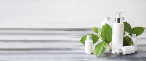 Different cosmetic products in bottles on wooden table with space for text