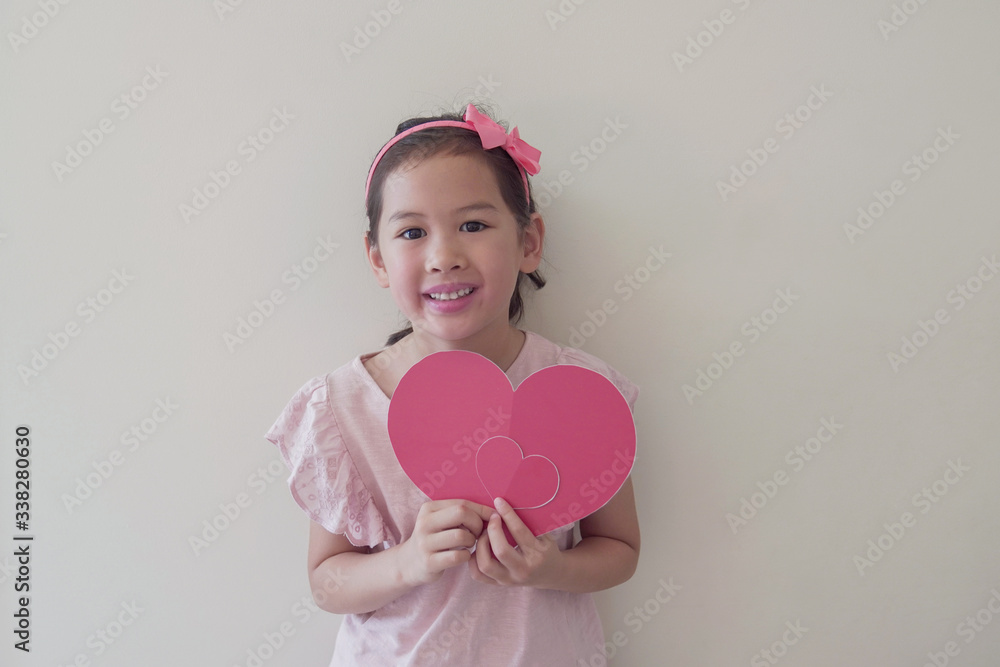 Wall mural Mixed race child holding big red heart, heart health, donation, happy volunteer charity, social responsibility,world heart day, world health day,world mental health day,  wellbeing, hope concept