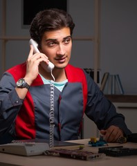 Young handsome repairman repairing computer