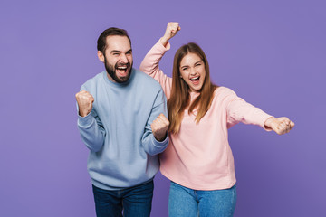 Optimistic loving couple make winner gesture.