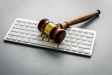 Gavel on laptop keyboard - Justice, law - on grey table