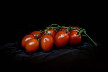 fresh red tomatoes isolated on dark background. Front view